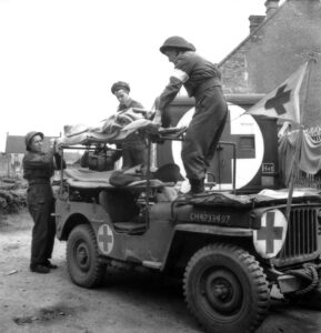 Medics load patient on jeep ambulance in Italy Source: Library and Archives Canada / PA-113872