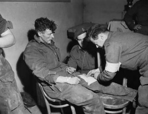 Medic checks dressing on injured soldier