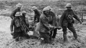 Stretcher bearers carry wounded through mud somewhere in France or Belgium